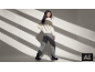 Femme portant un élégant pull blanc et un pantalon gris.