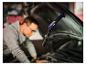 La lampe de travail LIVARNO® « The Mechanic » éclaire le compartiment moteur pendant qu'un homme travaille.
