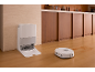 Aspirateur robot blanc avec sa station de charge sur un parquet de cuisine.