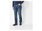 Un homme porte un jean droit et des bottines en cuir marron.