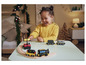 Un enfant joue avec des trains en bois et des rails.