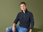 Homme portant un pull bleu marine zippé et un jean bleu.