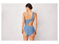 Une femme portant un maillot de bain bleu à une seule épaule.