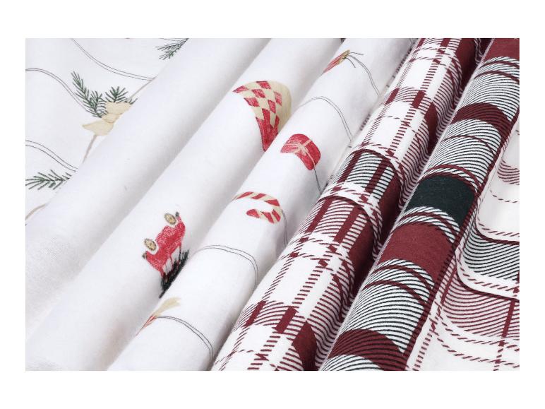 Parure de lit de Noël à carreaux avec des motifs festifs comme des sapins et des cadeaux.