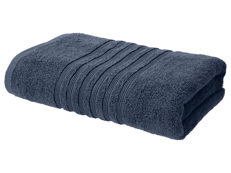 Serviette de bain pliée bleu foncé avec détails rayés