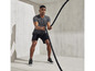 Homme en tenue de sport tirant sur une corde pendant un entraînement.