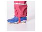 Pantalon de pluie rose avec des bottes bleues.