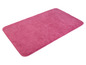 Un tapis de bain en peluche rose.