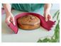 Un gâteau marbré sur un plateau à gâteau en verre, entouré d'un moule à gâteau en silicone rose.