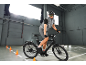 Homme sur un vélo électrique avec casque et lunettes, roulant en intérieur.