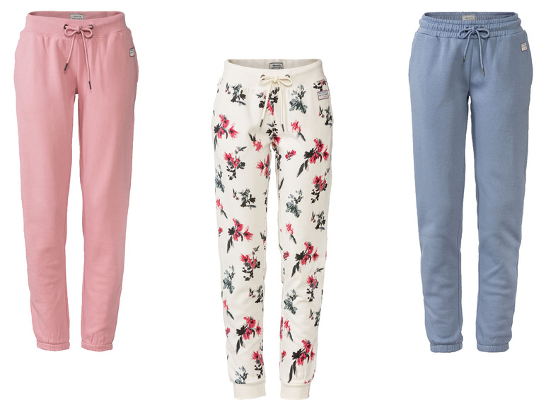 Trois pantalons de survêtement : un rose, un à fleurs et un bleu.