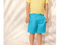 Un enfant porte un t-shirt jaune et un short bleu.