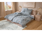 Chambre avec parure de lit bleue à motifs floraux, lit et tapis.