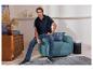Homme en pull en maille ESMARA MEN, polo et jean assis dans un fauteuil.