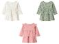 3 robes de bébé: blanche à pois, verte fleurie et rose à volants.