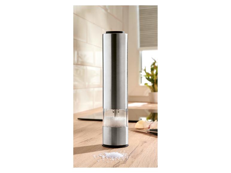 Moulin à sel électrique en acier inoxydable sur un comptoir de cuisine en bois.