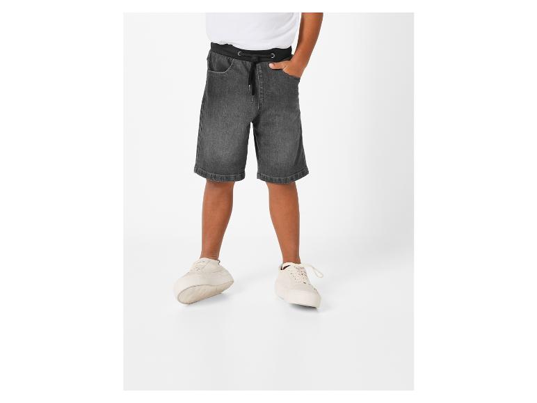 Shorts en jean gris foncé et baskets blanches pour garçon.