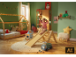 Chambre d'enfant avec lit cabane, toboggan, étagères et décorations de Noël.