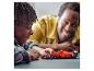 Un enfant et son père jouent avec une voiture de course LEGO Ferrari.