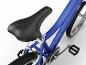 Gros plan sur un vélo enfant bleu avec une selle noire et des pédales.