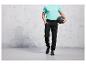Homme en pantalon de survêtement noir et un t-shirt bleu clair tenant un ballon médicinal