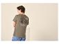 Homme de dos portant un t-shirt kaki avec un motif de montagne et un texte sur la nature.
