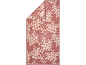 Tapis de bain rose avec motif floral clair, plié dans le coin supérieur gauche.