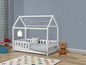 Un lit en bois blanc en forme de maison avec un ours en peluche