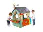 Deux enfants jouent avec une maison de jeu verte sur le thème Feber Eco House.