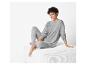 Une femme porte un pull gris et un legging.