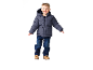 Garçon souriant en doudoune bleu foncé, jean et bottes marron.