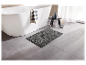 Tapis de bain gris foncé à côté d'une baignoire blanche.