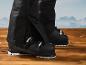 Des chaussures de ski noires sur un fond en bois