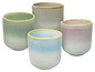 Quatre tasses en verre de différentes couleurs avec un effet dégradé.