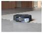 Aspirateur robot nettoyant un tapis dans une cuisine moderne.