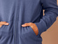 Un sweat-shirt bleu à fermeture éclair et poches.