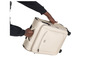 Une personne porte une valise beige à roulettes de la marque IT Luggage.