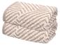 Deux serviettes pliées avec un motif zigzag marron clair et blanc