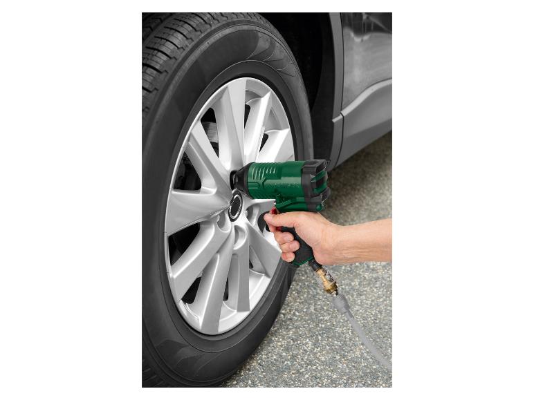 Une personne utilise une clé à chocs Parkside pour changer un pneu de voiture.