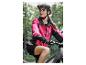 Une femme portant une veste de vélo rose et un short noir fait du vélo de montagne.
