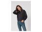 Femme en sweat-shirt noir et jean, souriante.