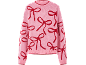 Pull en maille rose avec motif de nœuds rouges.