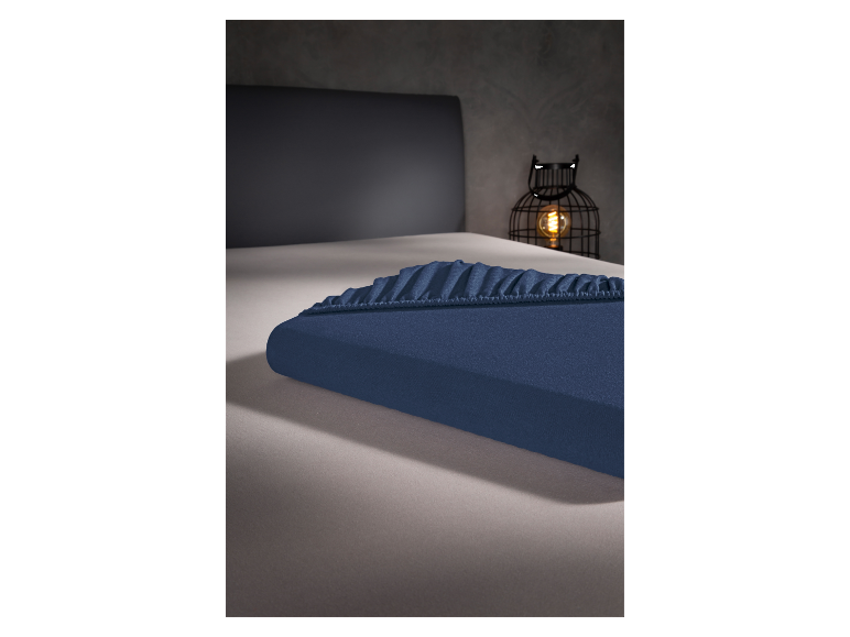 Un drap-housse bleu marine sur un lit.