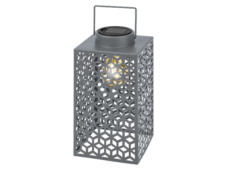 Lanterne solaire grise au design géométrique et lumière chaude.
