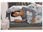 Femme dormant sur un oreiller ergonomique dans un lit avec une parure de lit fleurie.