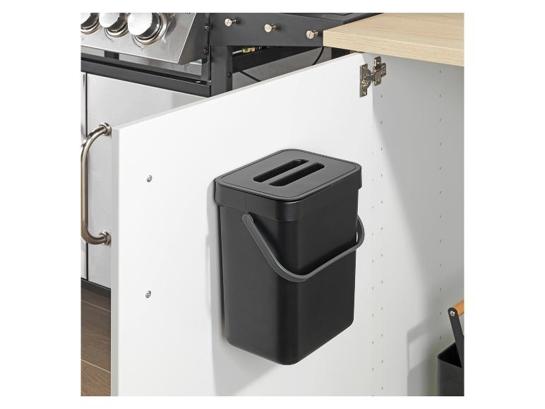 Une poubelle Brabantia noire montée dans une armoire de cuisine.
