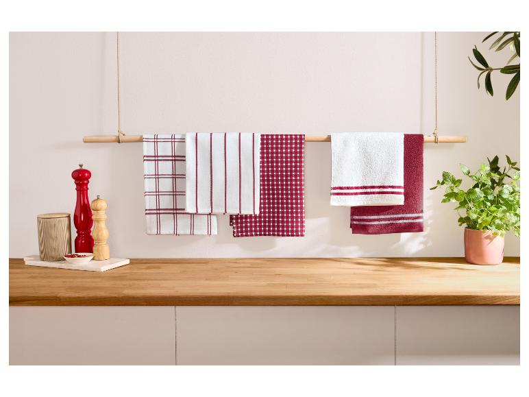 Torchons de cuisine rouges et blancs suspendus à une barre en bois.