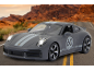 Voiture de sport miniature grise sur une route avec un canyon en arrière-plan