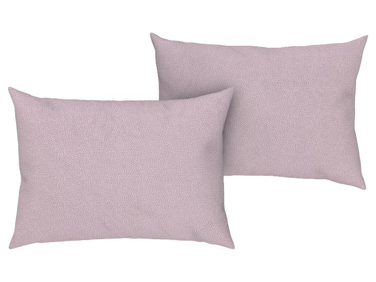 Deux oreillers lilas clair à pois blancs sont placés côte à côte.