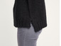 Un pull noir en maille avec un jean gris.